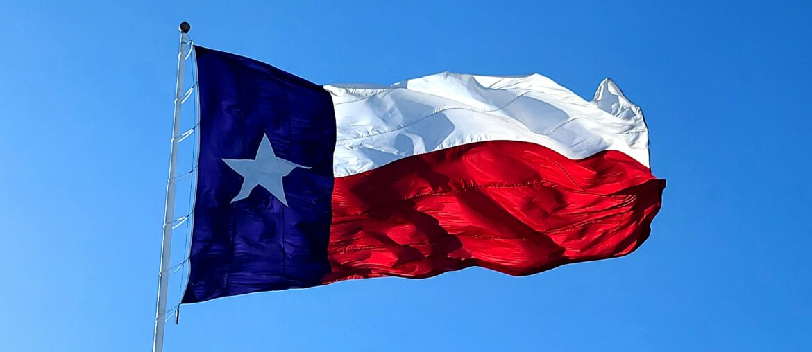 Texas flag waving on a clear, windy day