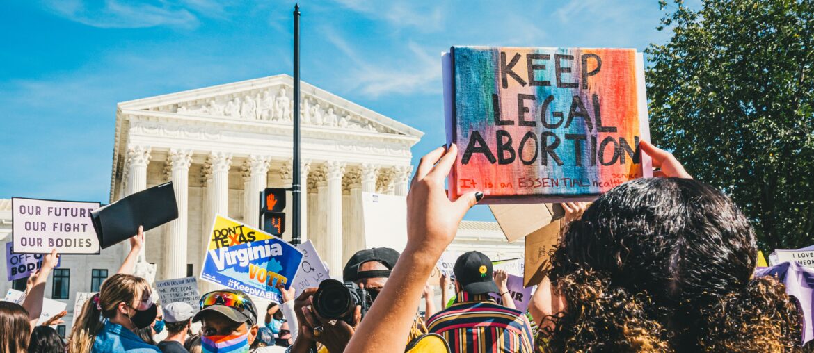 Protestors in front of Supreme Court building in Washington D.C. One woman is holding up a sign that says "Keep Abortion Legal"