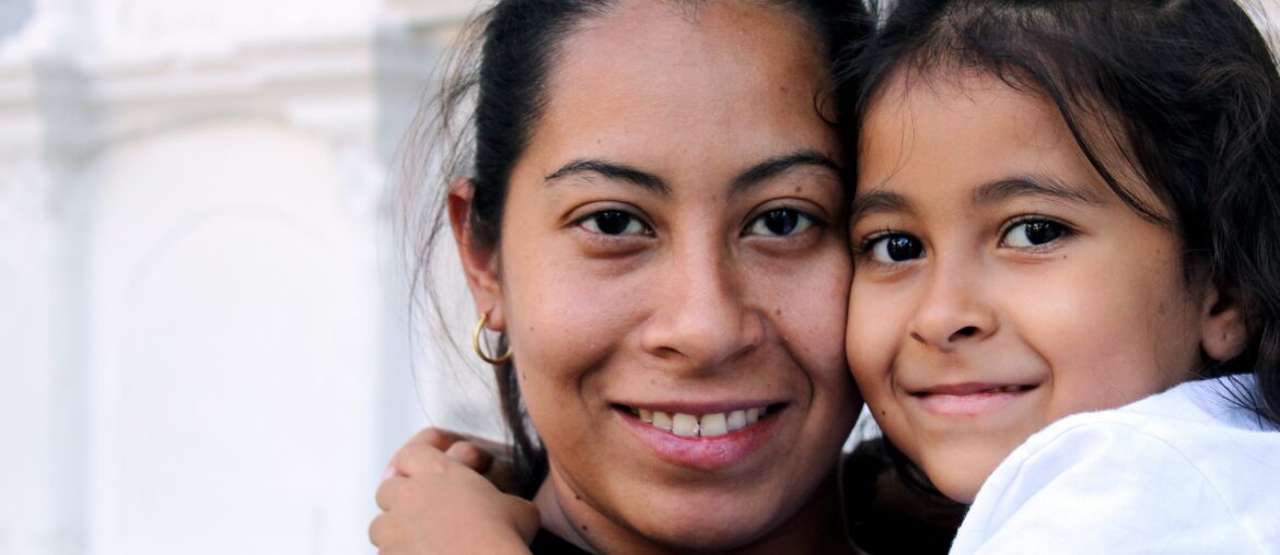 Mother and daughter looking at camera with white background