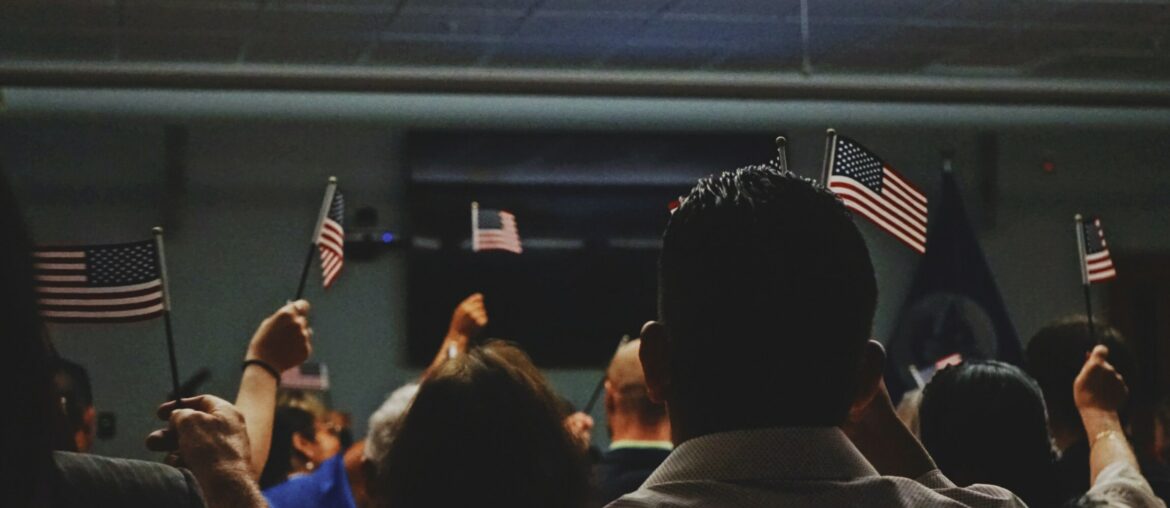 People holding up tiny American flags in a dark room