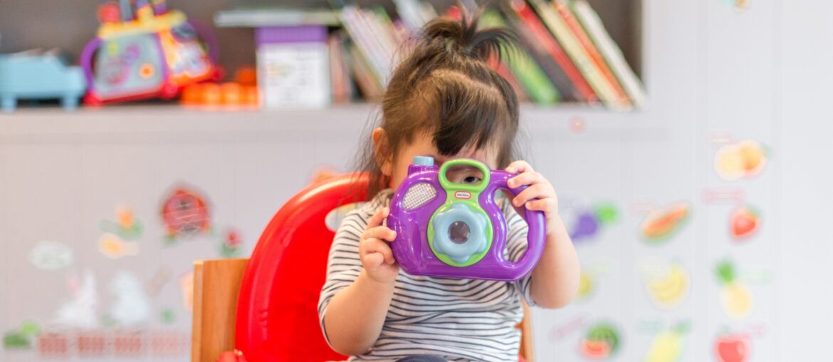 Young girl holding plastic toy camera