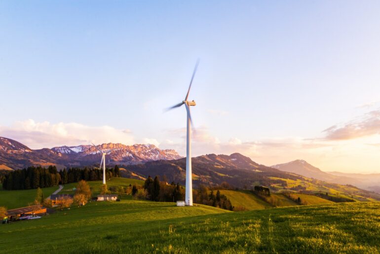 White windmill with mountains and the countryside in the background